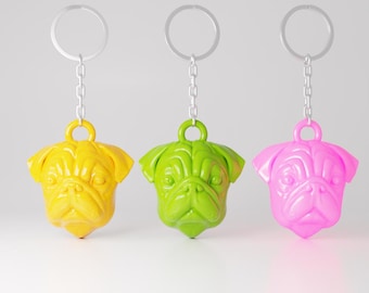 May include: Three keychains featuring a pug dog head design. The keychains are yellow, green, and pink.