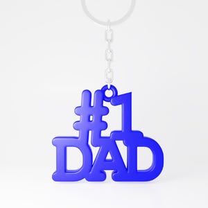 Pode incluir: Um chaveiro de metal azul com as palavras "#1 DAD" e uma corrente prateada.