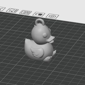 Könnte beinhalten: Graue 3D-gerenderte Entenfigur mit einer Schlaufe zum Aufhängen. Die Ente hat einen abgerundeten Körper, kleine Flügel und einen detaillierten Schnabel. Der Hintergrund ist ein Rastermuster.
