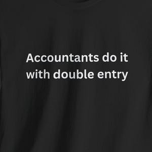 May include: Black t-shirt with the white text "Accountants do it with double entry." The shirt is made of a soft material and has short sleeves and a crew neck. The shirt is displayed on a dark background.