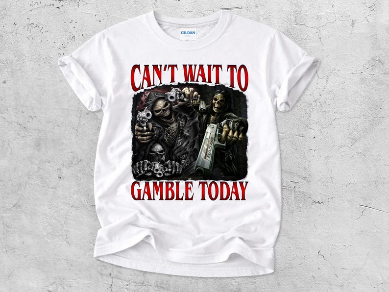 May include: White t-shirt with a graphic featuring skeletal figures holding guns, with the text "CAN'T WAIT TO GAMBLE TODAY" in red. The design is centered on the shirt.