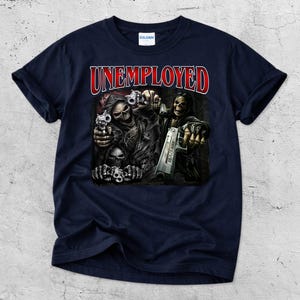 May include: Navy blue t-shirt with the word "UNEMPLOYED" in red lettering. The graphic features skeletal figures holding guns. The design is centered on the front of the shirt.