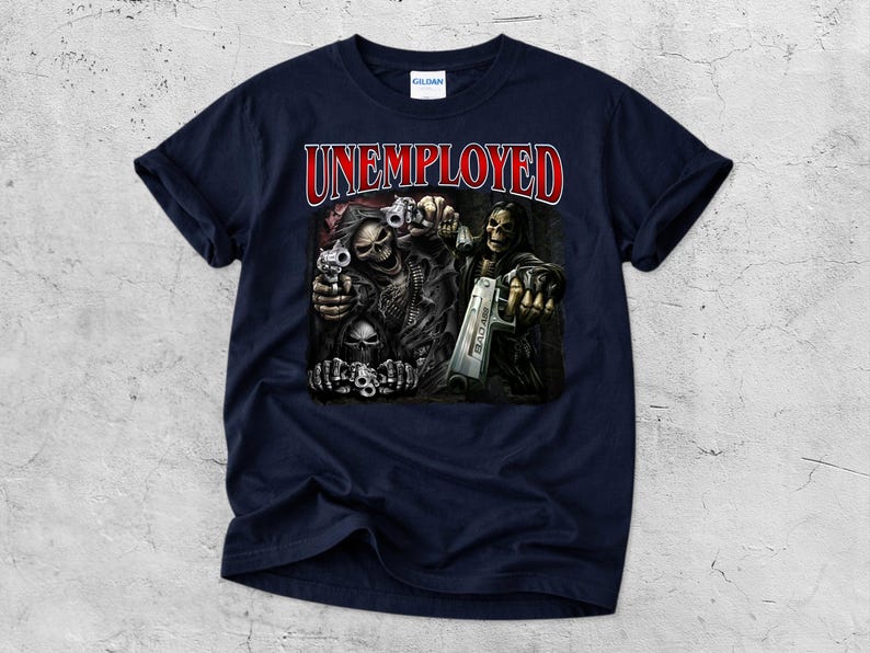 May include: Navy blue t-shirt with the word "UNEMPLOYED" in red lettering. The graphic features skeletal figures holding guns. The design is centered on the front of the shirt.
