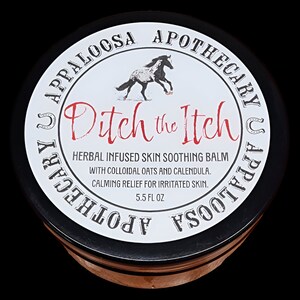 May include: A black jar with a white label that says "Appaloosa Apothecary U Appaloosa Apothecary" and "Ditch the Itch". The label also says "Herbal Infused Skin Soothing Balm with Colloidal Oats and Calendula. Calming Relief for Irritated Skin. 5.5 fl oz."