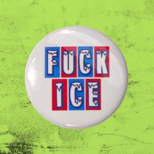 May include: A circular white pin-back button featuring the text FUCK ICE in bold, white, icicle-style lettering. The letters are set against alternating blue and red rectangular backgrounds, creating a high-contrast graphic design on the button.