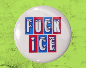 May include: A circular white pin-back button featuring the text FUCK ICE in bold, white, icicle-style lettering. The letters are set against alternating blue and red rectangular backgrounds, creating a high-contrast graphic design on the button.