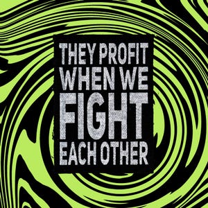 May include: A rectangular black fabric patch featuring the silver text "THEY PROFIT WHEN WE FIGHT EACH OTHER" in a bold, sans-serif font. The patch is centered against a background of swirling, high-contrast lime green and black liquid patterns.