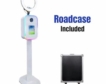 May include: A white photo booth with a ring light, a touch screen, and a camera. The booth has a colorful LED border and is mounted on a stand. The text "Roadcase Included" is displayed. A black road case with wheels is also shown.