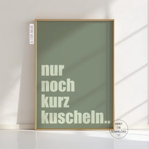 Può includere: Una stampa artistica incorniciata con uno sfondo verde salvia e una cornice dorata. La stampa presenta il testo tedesco "nur noch kurz kuscheln..." in un carattere bianco sporco in grassetto. Le parole si traducono in "abbracciarsi un po'". La frase "TUTTI I COLORI DISPONIBILI" è stampata sul lato sinistro.