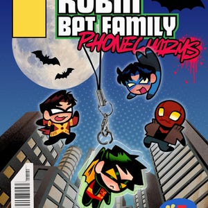May include: A clear acrylic phone charm featuring a chibi-style character with black hair, a green mask, and a red and yellow suit. The charm hangs from a black cord against a comic book background with text reading ROBIN BAT FAMILY PHONE CHARMS.