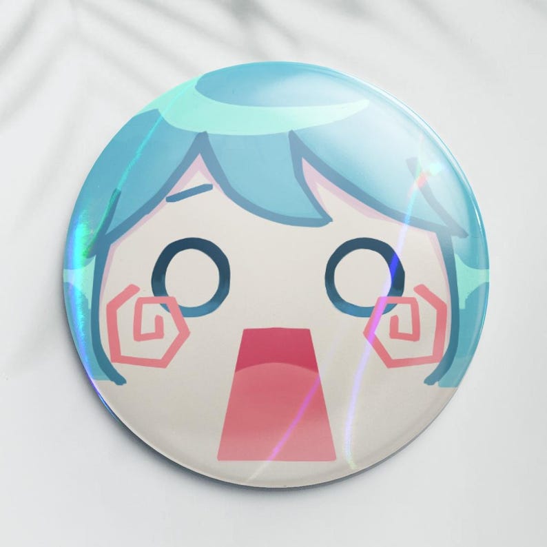 May include: A round, holographic button featuring a surprised cartoon character with blue hair and large eyes. The character's mouth is open, and pink swirls accent the cheeks. The button has a glossy finish and a white background.