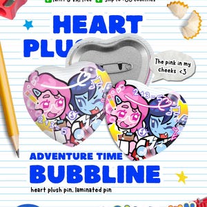 May include: Heart-shaped Adventure Time Bubbbline pins. The pins feature cartoon characters in pink and blue, with the text "The pink in my cheeks <3". The background includes a pencil, sharpener, and the text "HEART PLU".