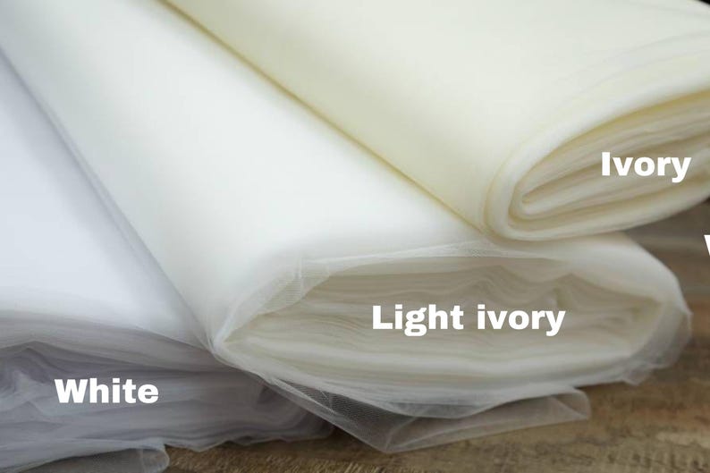 May include: Three rolls of tulle fabric in different shades of white: white, light ivory, and ivory.