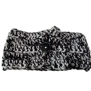 Peut inclure: Un bandeau crocheté noir et blanc avec une grande fermeture à bouton foncé. Le chauffe-oreilles fait à la main présente un motif tricoté épais et texturé. Le jeu de couleurs est un mélange de noir et de blanc, créant un contraste saisissant. Cet accessoire douillet est parfait pour le froid.