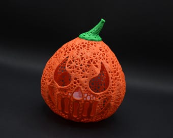 May include: Orange pumpkin-shaped Halloween lantern with a green stem and a detailed, intricate design. The lantern is made of a thin, translucent material and has a spooky face carved into it.