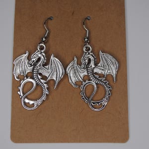 Dragon earrings. Silver jewelry. Statement accessories. Dungeons and dragons themed. Fantasy and mythical vibes.