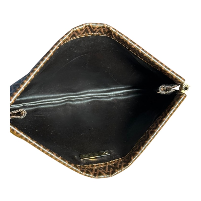 May include: The inside of a brown and black patterned clutch bag with a black lining. The bag has a gold zipper.