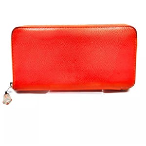 May include: A bright orange leather zippered wallet. The wallet is closed and the zipper pull is visible.