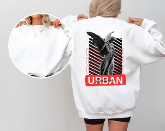May include: White sweatshirt with a graphic print of an angel statue and the text "URBAN STREETWEAR" in red.