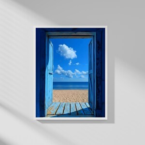 Puede incluir: Una impresión enmarcada de una escena de playa vista a través de una puerta de madera azul. La puerta abierta revela una playa de arena, un océano azul y un cielo azul brillante con nubes blancas y esponjosas. El marco de la puerta y las contraventanas están pintados de azul vibrante.