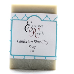 May include: A bar of green soap with a label that reads "Elegant Rose Cambrian Blue Clay Soap 5 oz".