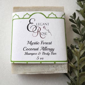 May include: A rectangular shampoo and body bar with a white label featuring the text "Elegant Rose" and "Mystic Forest Coconut Allergy Shampoo & Body Bar". The bar is 5 oz.