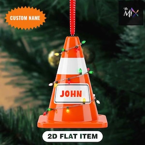 May include: Orange and white traffic cone Christmas ornament with the name "JOHN" on a white sign. The ornament is decorated with a string of colorful lights and a red and white polka dot ribbon for hanging. The text "2D FLAT ITEM" is at the bottom.
