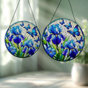 May include: Two round stained glass window hangings with a blue and green floral design featuring irises and butterflies.