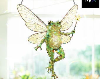 May include: A decorative green frog with fairy wings and a star wand, suspended by a chain. The frog has a shimmering, iridescent finish. The image includes the text "The Mix" in the upper right corner.