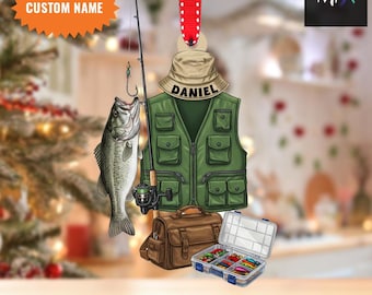 Könnte beinhalten: Personalisierter Angel-Weihnachtsschmuck mit grüner Angelweste, Angelrute, Fisch, Tacklebox und brauner Angeltasche. Der Schmuck hat den Namen "DANIEL" auf einem Hut und den Text "CUSTOM NAME" auf einem Stern.