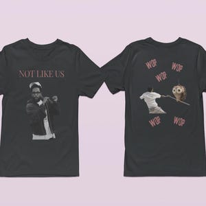 May include: Black t-shirt with a graphic of a man wearing a jacket and the text "NOT LIKE US" on the front. The back of the shirt has a graphic of a man holding a stick with a bird on the end and the word "WOP" repeated four times.