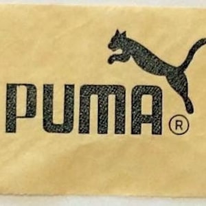 May include: A brown paper tag with the black Puma logo and the word "PUMA" in black lettering with a registered trademark symbol.