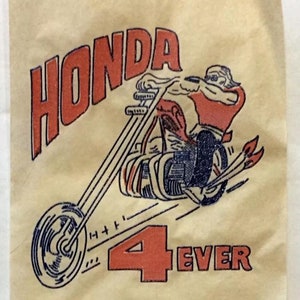 May include: Tan fabric with a vintage-style graphic of a motorcycle and rider. The word "HONDA" is in red block letters above the image. Below the motorcycle is the phrase "4 EVER" in red. The image includes instructions.