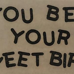 May include: A light beige background with the phrase "YOU BET YOUR SWEET BIPPY" in black, stylized, stitched lettering. The text is arranged in three lines, with each word centered.