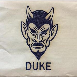 May include: A blue and white illustration of a devil's head with horns and the word "DUKE" printed below.
