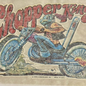 May include: A vintage iron-on patch featuring a cartoon illustration of a motorcycle rider on a chopper with the text "Chopper King" in red and white lettering. The motorcycle has flames coming out of the exhaust pipe.