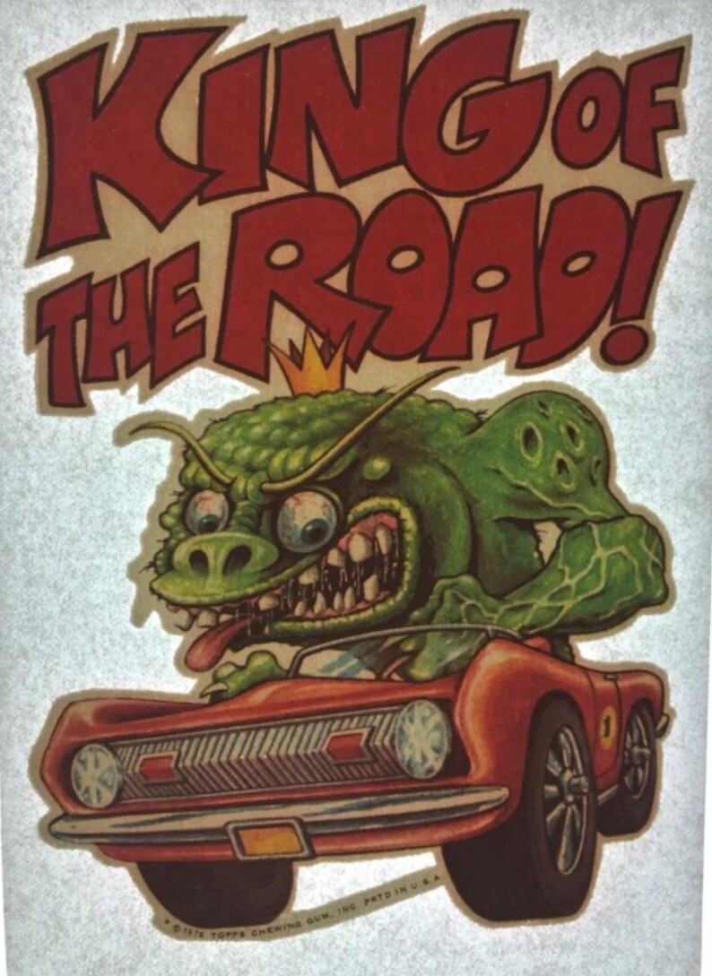 K&ouml;nnte beinhalten: Ein gr&uuml;nes Monster mit einer Krone f&auml;hrt ein rotes Auto mit den Worten "King of the Road!" in roten Buchstaben &uuml;ber dem Auto.