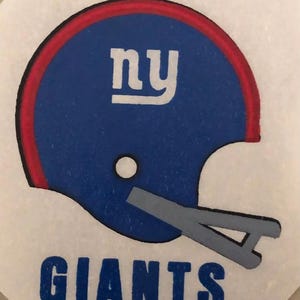 May include: A blue and red football helmet with a white "NY" logo and the word "GIANTS" in blue lettering.