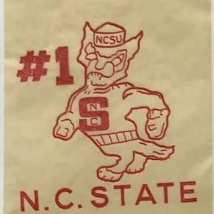May include: Red and white #1 N.C. STATE mascot with a wolf head and a hat that says NCSU.