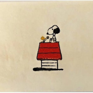 May include: A black and white illustration of Snoopy sitting on top of his red doghouse with a yellow bird perched on the edge.