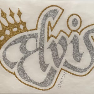 May include: A glittery iron-on transfer featuring the word Elvis in silver cursive script with a gold glitter crown positioned above the letters. The entire design is outlined in gold glitter, and the text Elvis is clearly visible in the center.