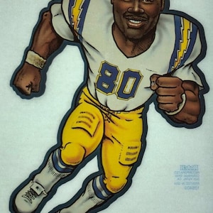 May include: A cartoon illustration of a football player wearing a white and yellow uniform with the number 80 on the front. The player is running with the ball and has a determined expression on his face. The image is signed "Kellen Winslow" and includes the copyright information "©1981 LUSTIG PRO SPORTS ART INC."