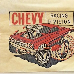 May include: A red Chevy race car with flames coming out of the back wheels. The car has a large engine and is labeled "CHEVY RACING DIVISION".