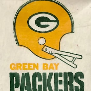 May include: Green Bay Packers logo on a white background. The logo features a yellow and green football helmet with a green "G" inside. The words "Green Bay Packers" are written in green below the helmet.
