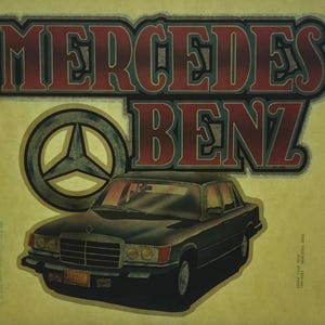 K&ouml;nnte beinhalten: Ein Vintage-B&uuml;geleisen-Patch mit einem schwarzen Mercedes-Benz-Auto mit dem ikonischen dreizackigen Stern-Logo und dem Text "Mercedes Benz" in roten und blauen Buchstaben.