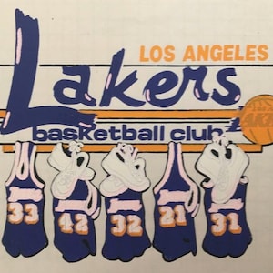 May include: A vintage Los Angeles Lakers basketball club graphic with the team name in purple and pink lettering. The graphic features five basketball jerseys with the numbers 33, 42, 32, 21, and 31 on them.
