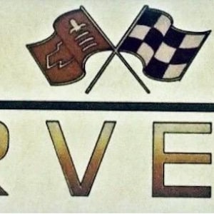 May include: A rectangular decal featuring the word CORVETTE in large, bold, gradient-filled letters. Above the text is a horizontal black line and two crossed flags: one brown flag with a white emblem and one black and white checkered flag.