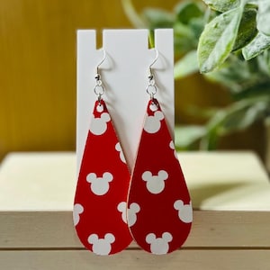 Puede incluir: Un par de pendientes rojos en forma de l&aacute;grima con un estampado de Mickey Mouse blanco. Los pendientes cuelgan de ganchos plateados. Un accesorio divertido y juguet&oacute;n, exhibido en un soporte blanco.