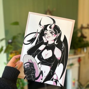 Puede incluir: Ilustración en blanco y negro de un personaje con cuernos de diablo, alas y un recorte en forma de corazón en el pecho. La obra de arte presenta una combinación de colores rosa y negro con un estilo pop art. El texto "IN PLAIN SIGHTE" es visible.
