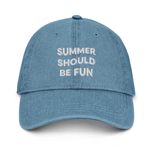 Op de afbeelding: Een blauwe spijkerstof baseballpet met de wit geborduurde tekst SUMMER SHOULD BE FUN gecentreerd op het voorpaneel. De pet heeft een gebogen klep, een knoop aan de bovenkant en gestikte oogjes voor ventilatie in een klassiek ontwerp.
